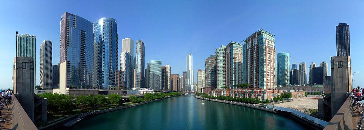 people walking along the Chicago Riverwalk with the skyline in spring light
